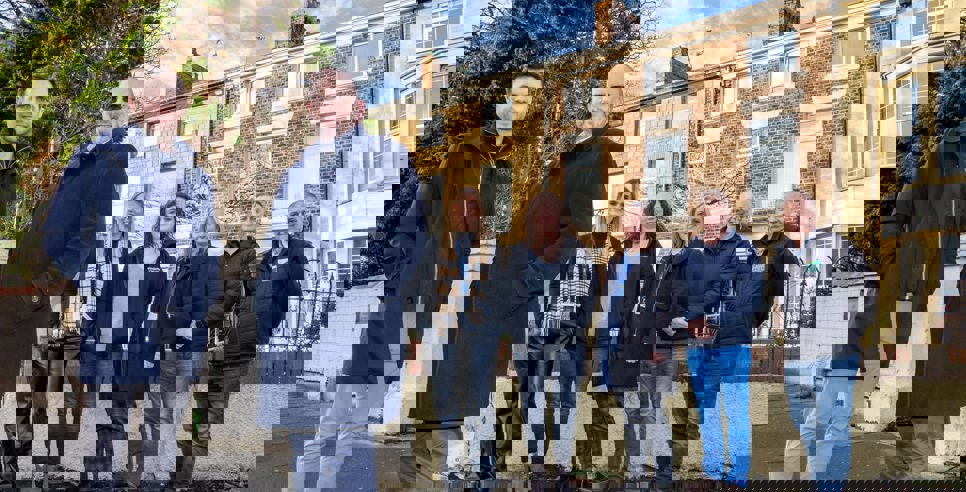 Representatives from Zenith Mechanical Services, Prosper, Tyne Housing, Keelman Homes, North Star Housing, Livin Housing, and Durham Aged Mineworkers’ Homes smiling outside a terraced property