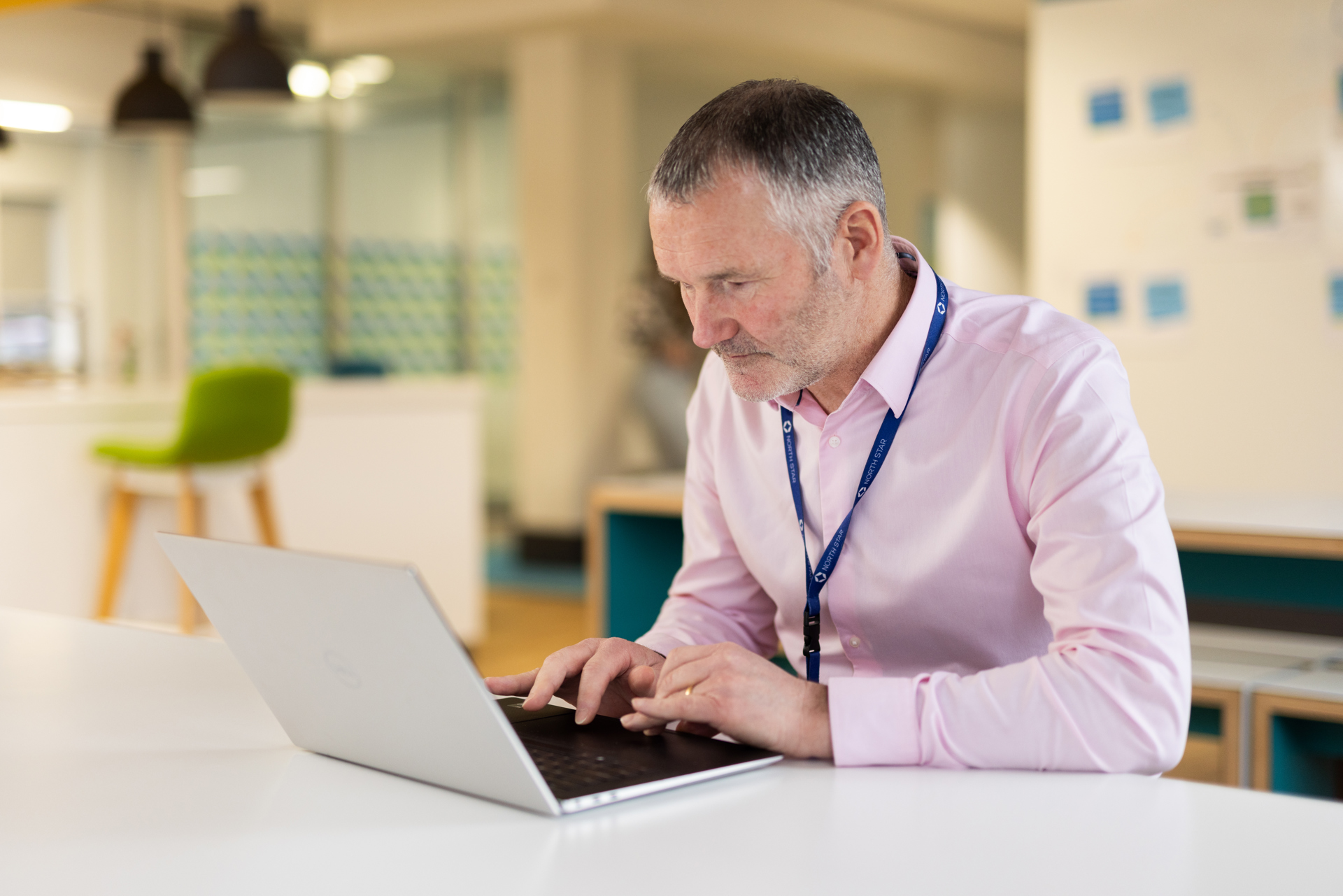 Person sat working on a laptop in a modern office.