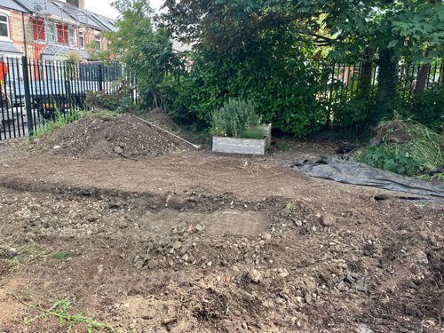 Muddy area of a community garden with uneven ground