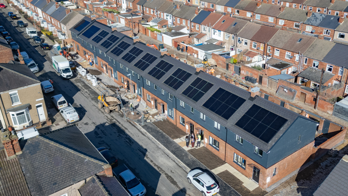 Drone shot of 12 newly built terraced homes with solar panels