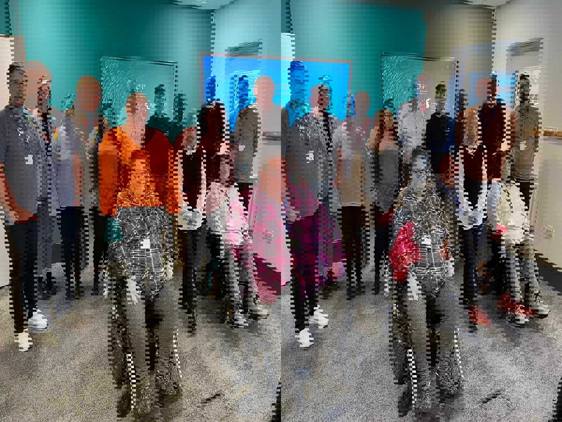 A group of North Star staff and tenants of a variety of ages, genders, and ethnicities. Two members of the group are wheelchair users.